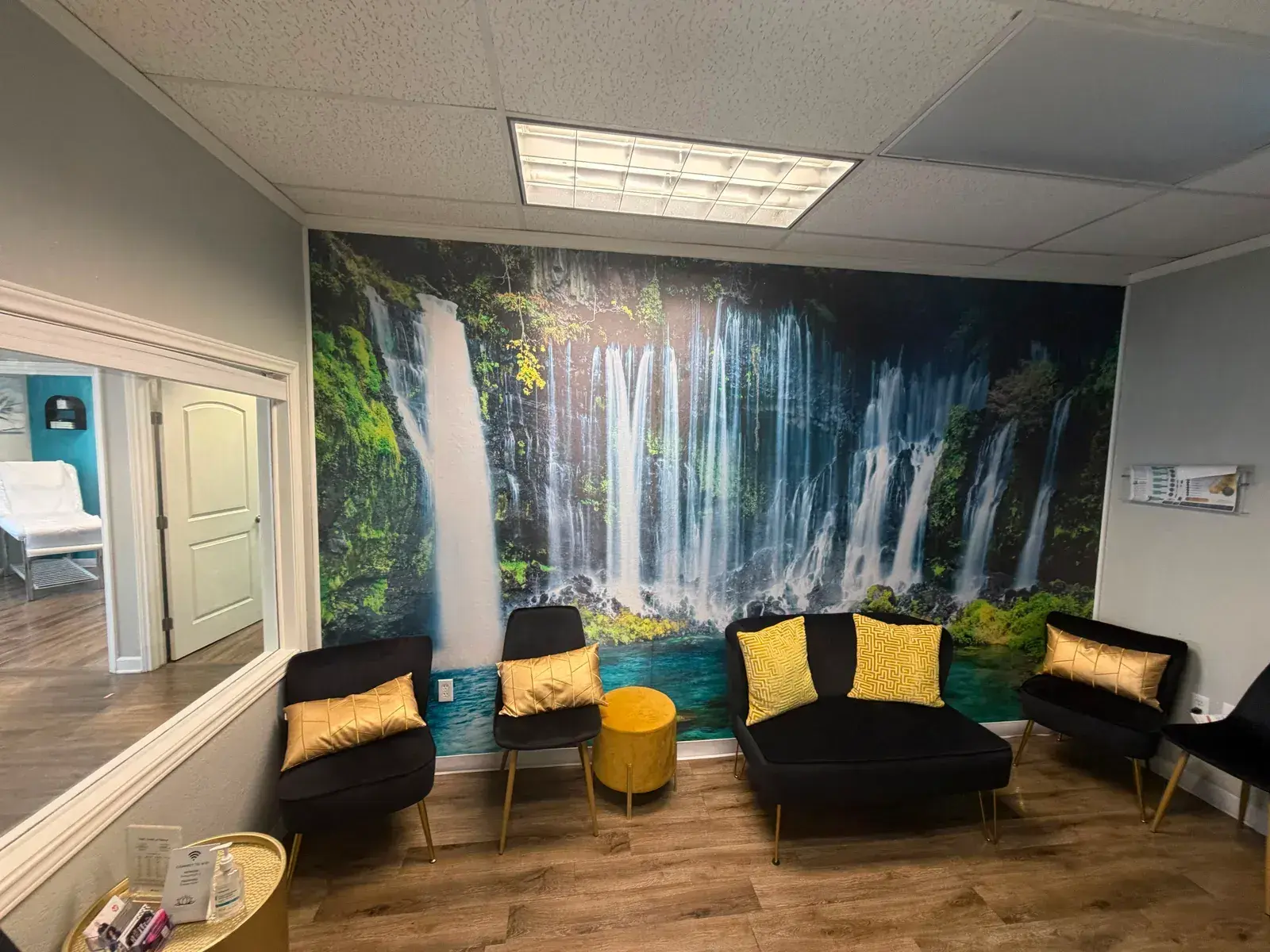 The Tranquility recovery lounge, with velvet seating and gold cushions set against a waterfall mural